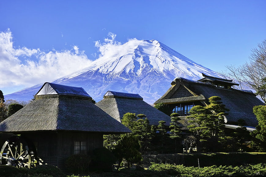 Traditional Japanese Thatched Huts with Mount Fuji Background