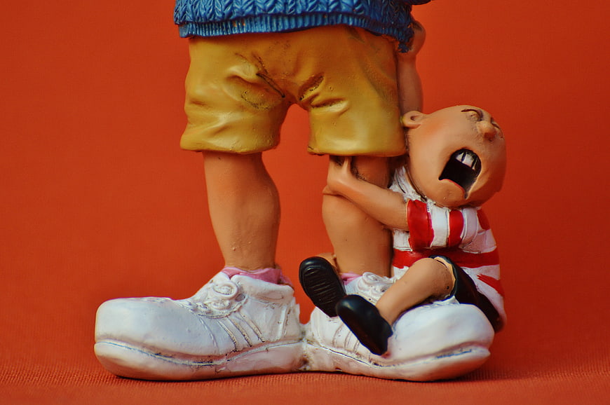 Cute Figurine of Crying Child Clinging to Adult Legs