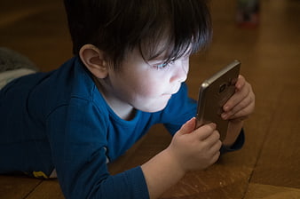 Toddler Boy Lying on Floor Using Smartphone