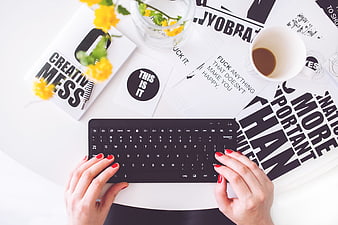 Top view of woman typing on keyboard with creative workspace