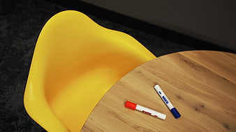 Yellow chair and markers on wooden table