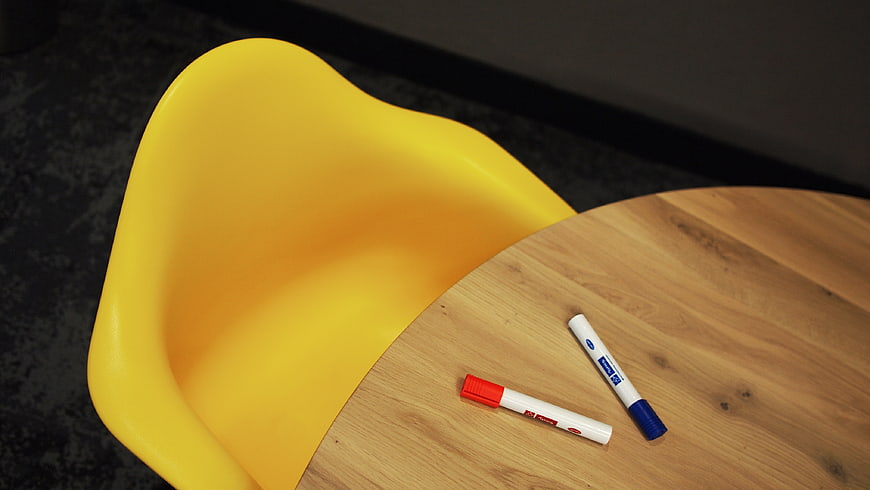 Yellow chair and markers on wooden table