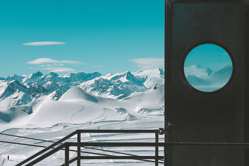 Snowy mountain landscape viewed through a circular window