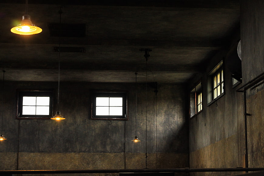 Moody Abandoned Industrial Interior With Hanging Lights And Windows