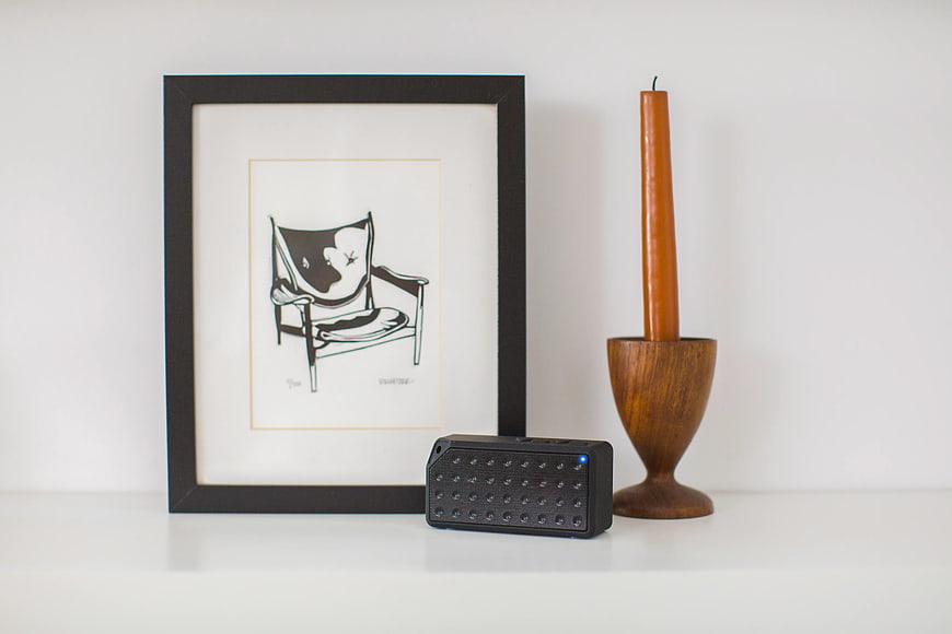 Minimalist Shelf with Black Speaker, Wooden Candle Holder, and Framed Art