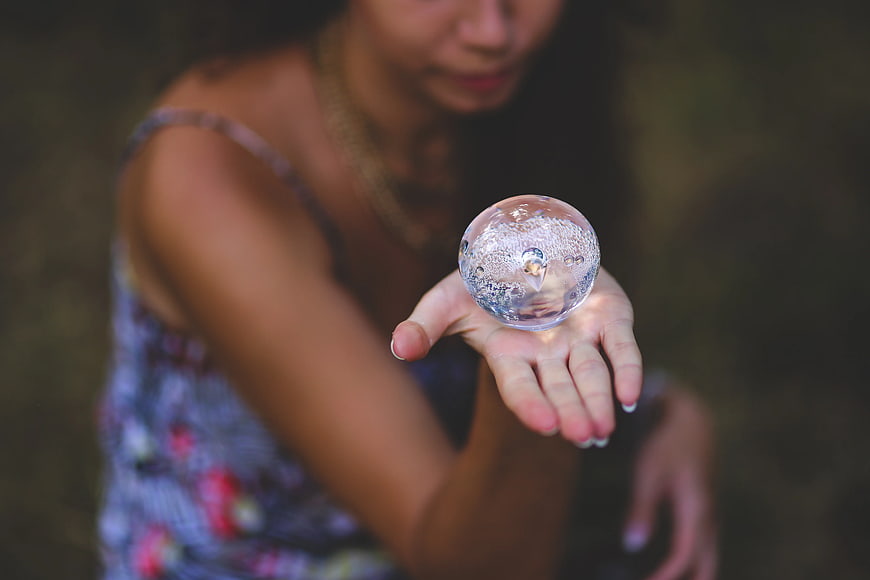 Woman holding crystal ball in hand with blurred background