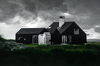 Modern Black House in Rural Landscape Under Stormy Sky