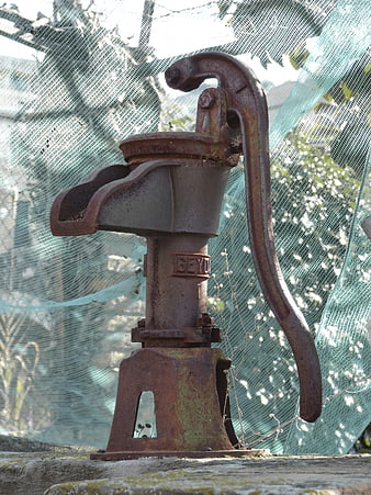 Rusty vintage hand water pump outdoors