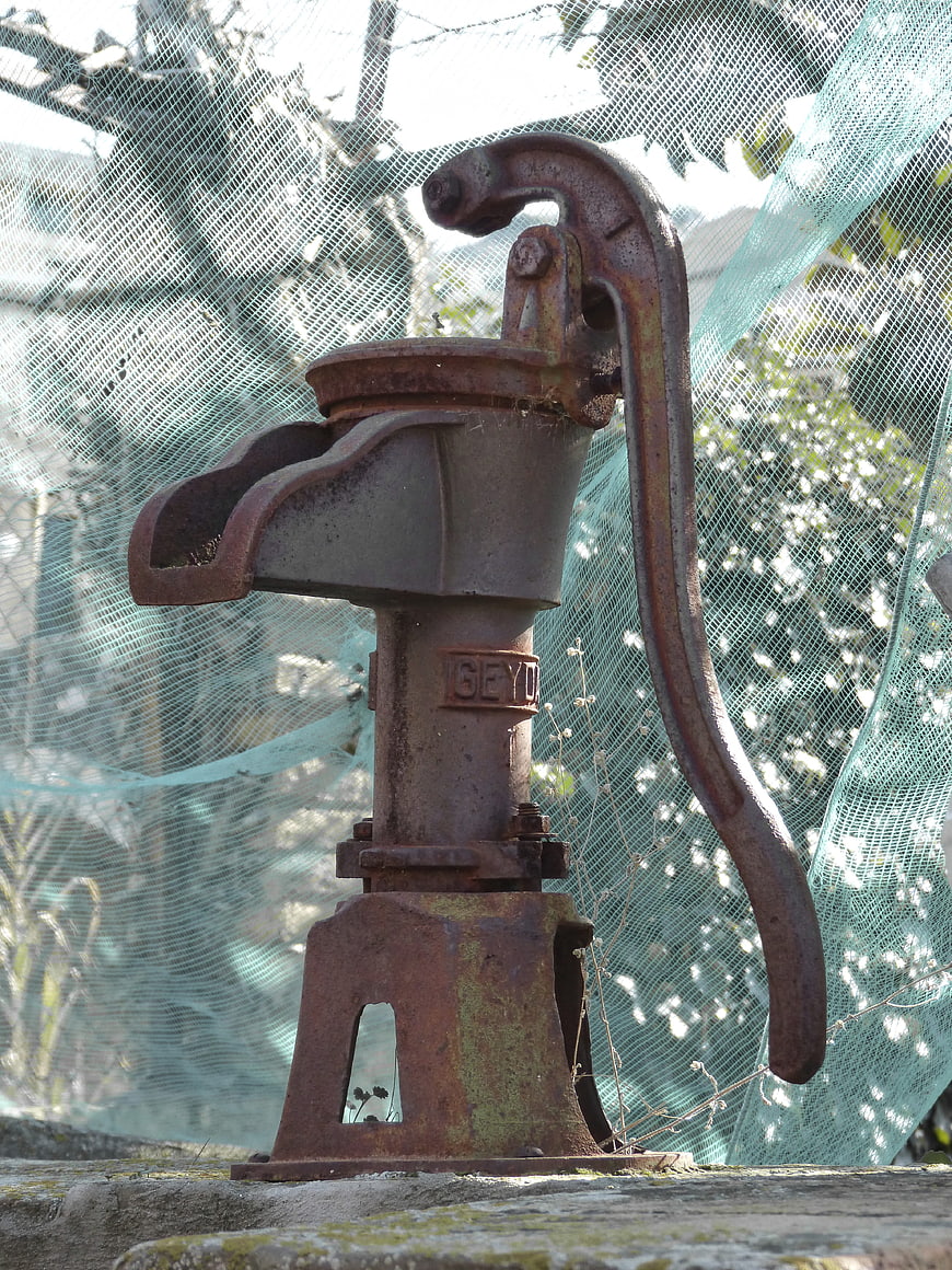 Rusty vintage hand water pump outdoors