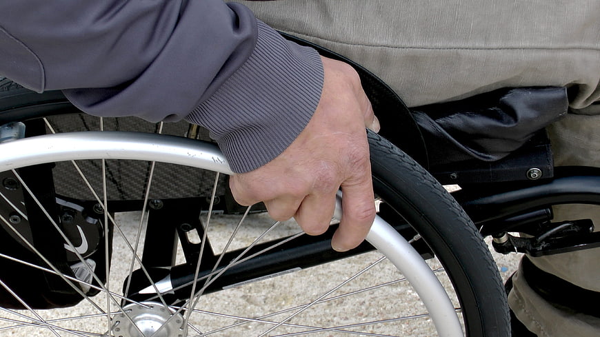 Close-up of hand gripping wheelchair wheel rim