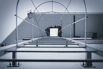 Low angle view of metal walkway structure on industrial rooftop
