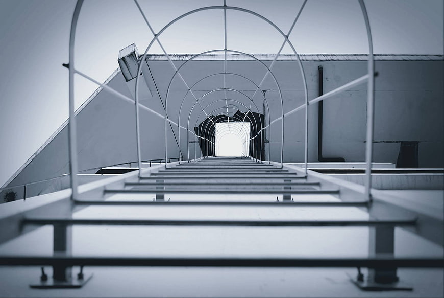 Low angle view of metal walkway structure on industrial rooftop