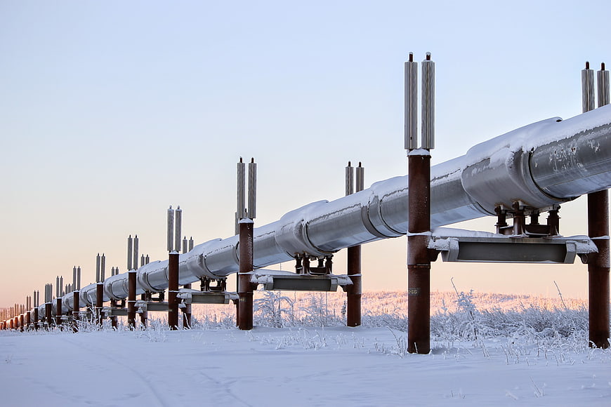 Snow-covered industrial pipeline structure in a winter landscape