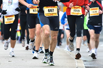 Low angle view of marathon runners legs and race bibs