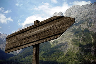 Blank wooden signpost against majestic mountain landscape