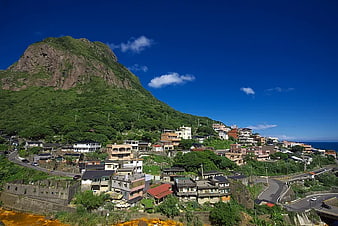 Coastal Village at the Base of a Green Mountain
