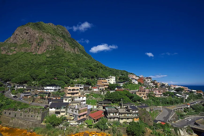 Coastal Village at the Base of a Green Mountain
