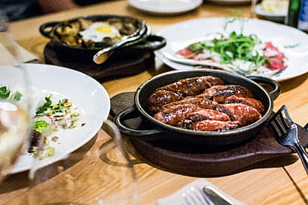 Sizzling sausages in cast iron skillet at restaurant