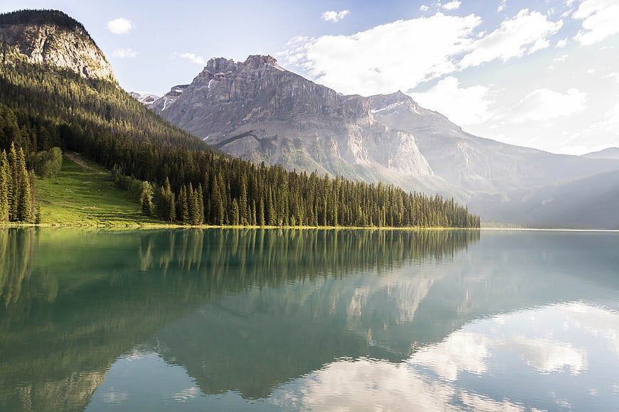 Serene Mountain Lake with Forest Reflections and Rocky Peaks