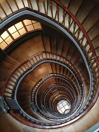 Top-down view of a wooden spiral staircase in an office building