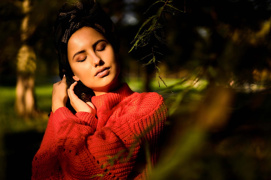 Woman in Red Sweater with Eyes Closed in Sunlight