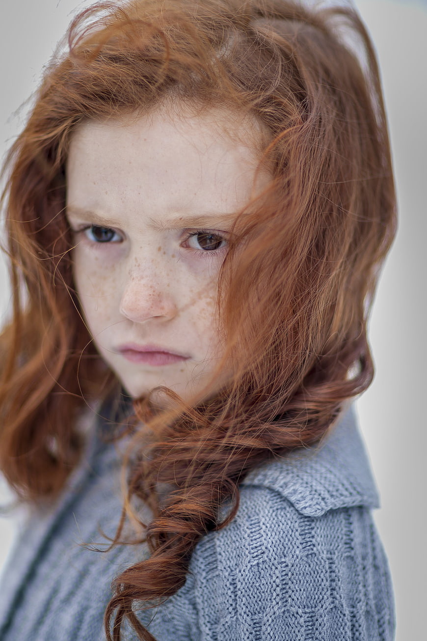 Portrait of a young girl with red hair and freckles