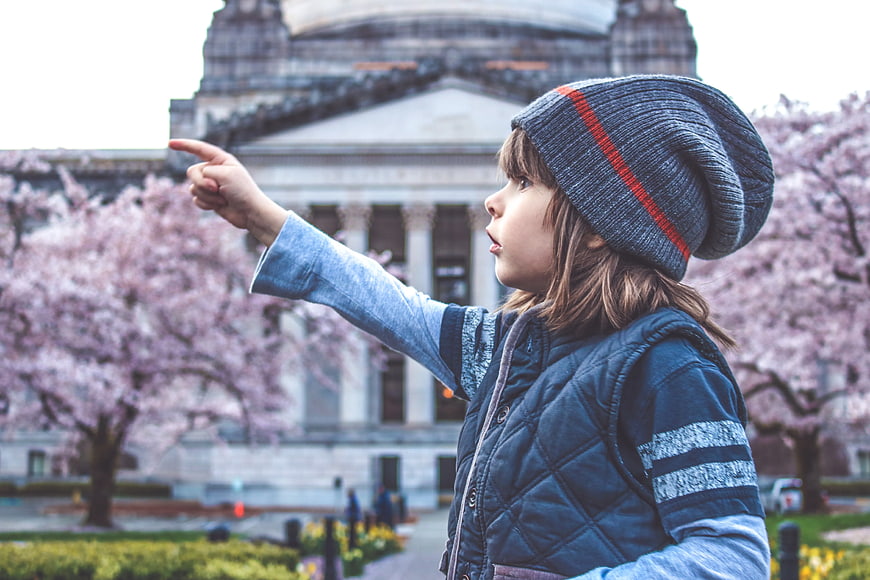 Child pointing at museum with cherry blossoms