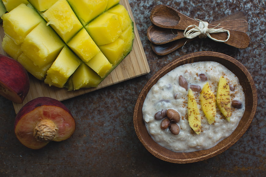 Overhead view of coconut rice pudding with mango and beans