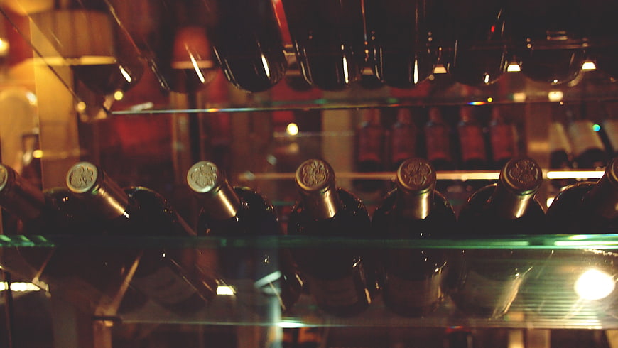 Rows of wine bottles in a dimly lit cellar
