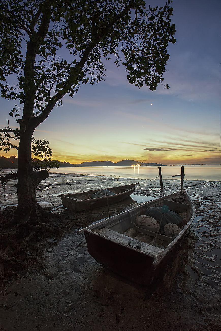 Wooden Fishing Boats on Muddy Shore at Sunset