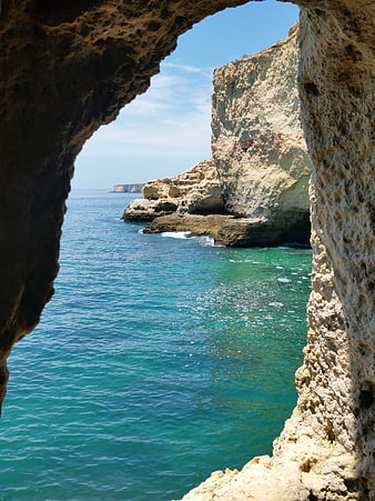 View of turquoise sea through a natural rock archway