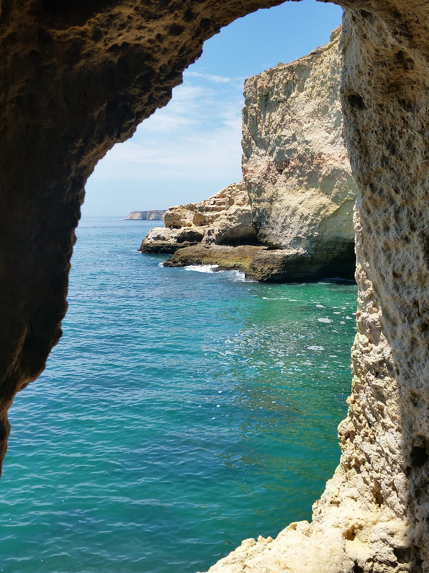 View of turquoise sea through a natural rock archway