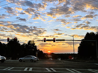 Dramatic Sunset Over Urban Intersection with Traffic Lights