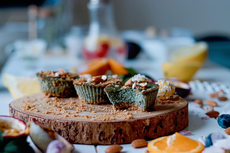 Green Matcha Mini Tarts with Almonds on Wooden Board