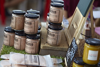 Artisanal body scrub jars displayed at a market stall