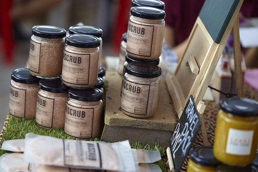Artisanal body scrub jars displayed at a market stall