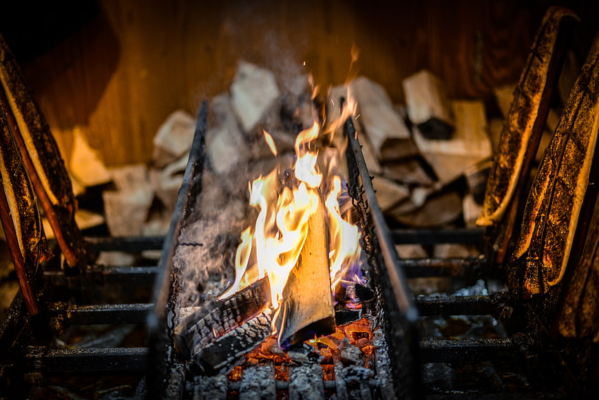 Close-up of burning wood logs in a charcoal grill