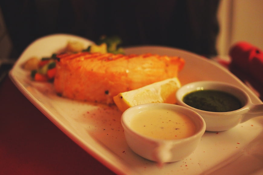 Grilled Salmon Fillet with Sauces and Lemon on White Plate
