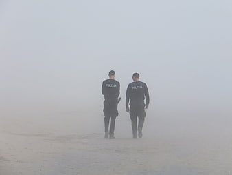 Two Police Officers Walking Away in Thick Fog