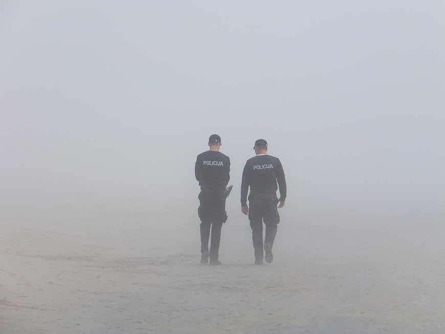 Two Police Officers Walking Away in Thick Fog