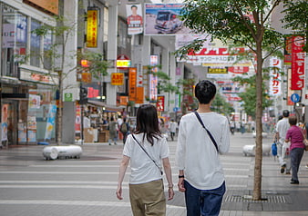 Couple Walking Through Bustling Japanese Shopping Street