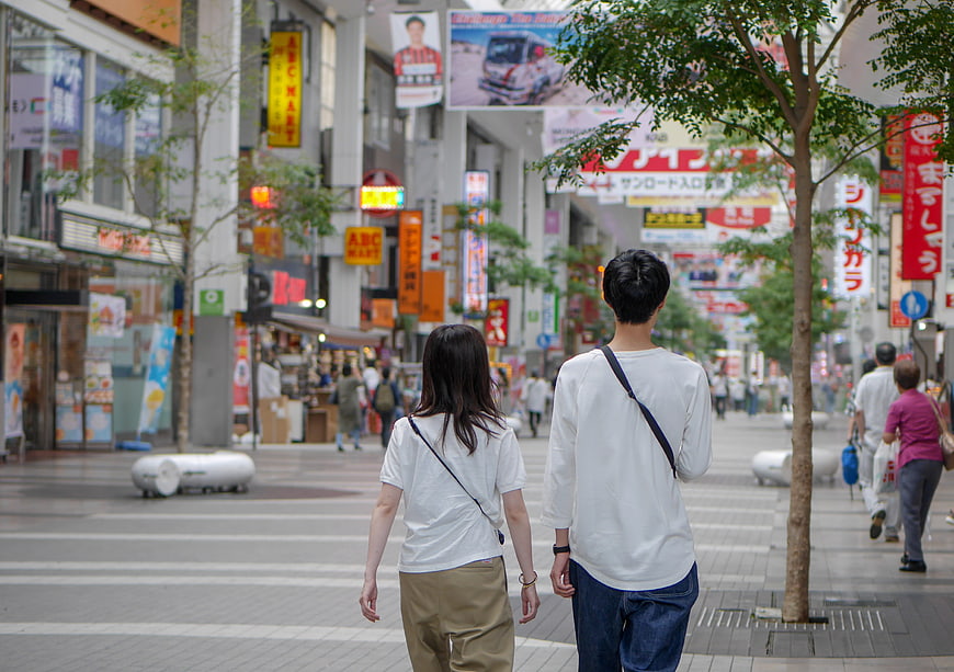 Couple Walking Through Bustling Japanese Shopping Street