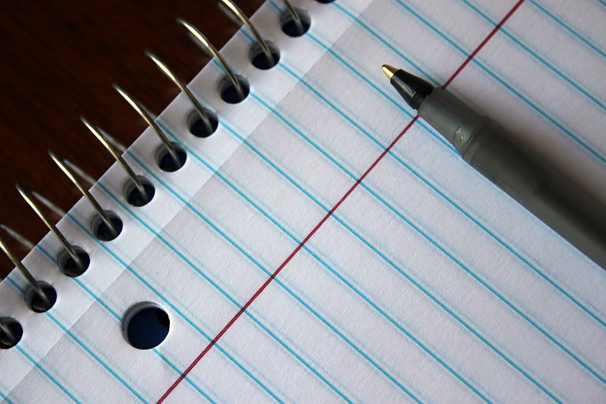Blank spiral notebook and pen on wooden desk