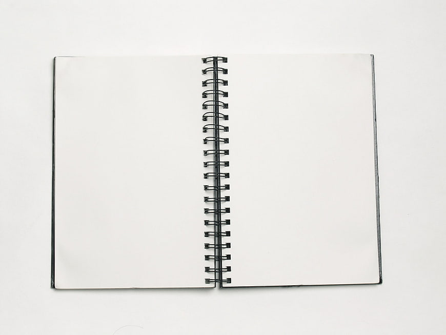 Blank spiral notebook open on white background