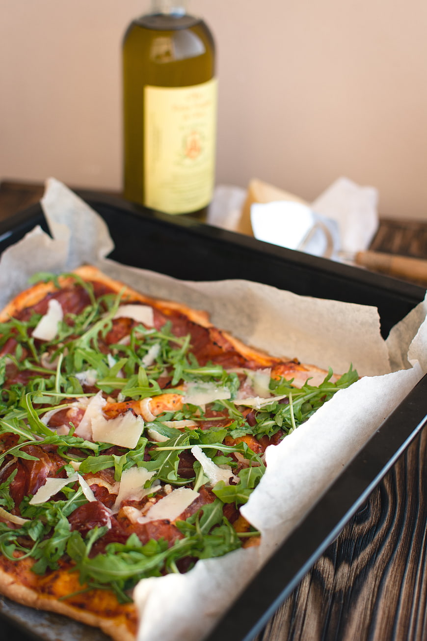 Homemade Pizza with Arugula and Prosciutto on Baking Sheet