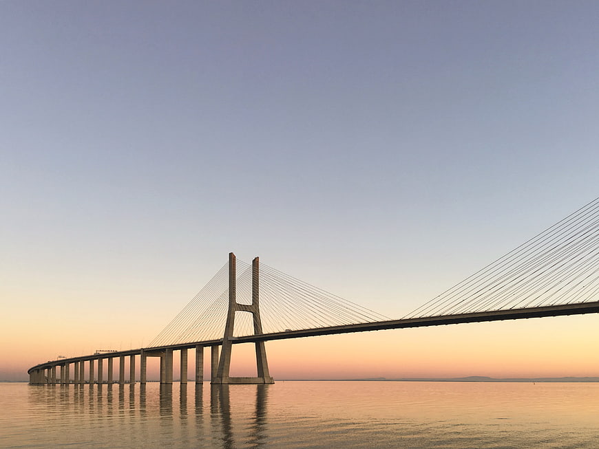 Cable-stayed bridge over calm water at sunset