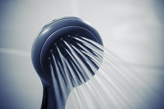 Close-up of blue shower head spraying water streams