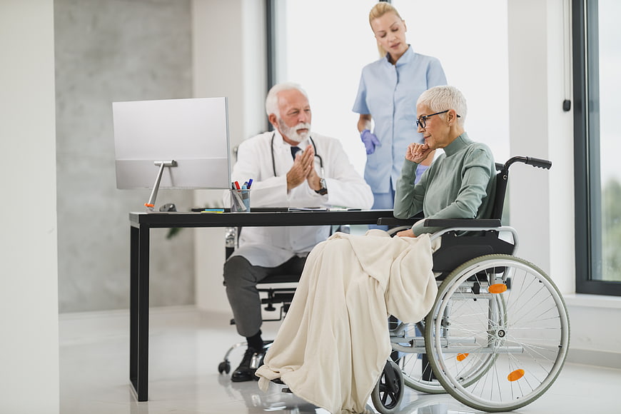 Senior Doctor Consulting Elderly Patient in Wheelchair