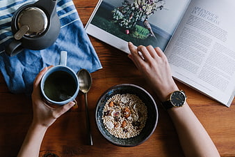 Overhead view of breakfast with tea, cereal, and magazine