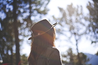 Woman in Fedora Hat Looking at Nature with Sun Flare